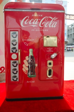 Máquina da Coca-Cola na cidade de Guangzhou, na China. A difusão das multinacionais permite o rápido acesso ao mercado consumidor. ¹