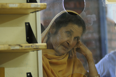 Uma senhora sobrevivente do acidente em Bhopal à espera de medicamentos gratuitos em uma clínica dedicada às vítimas do desastre*