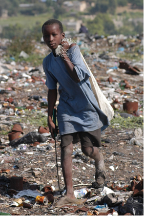 MAPUTO,MOÇAMBIQUE - maio de 2004: Uma criança com fome coleta lixo em um aterro sanitário*