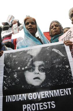 Vítimas segurando uma imagem de uma criança morta na tragédia de Bhopal*